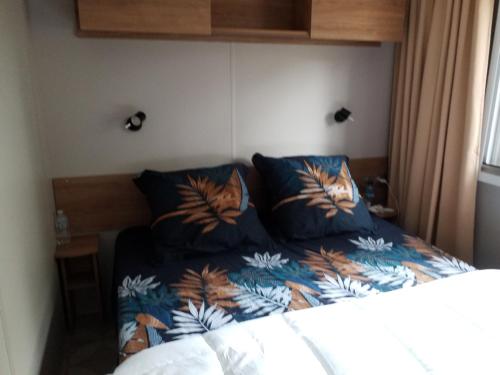 圣布里文莱丝皮恩Mobil home Aventura 6-8 personnes tout confort的一间卧室配有一张带蓝色棉被的床
