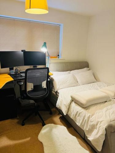 巴塞尔顿Play Away Lodge的一间卧室配有一张桌子、一台电脑和一张床