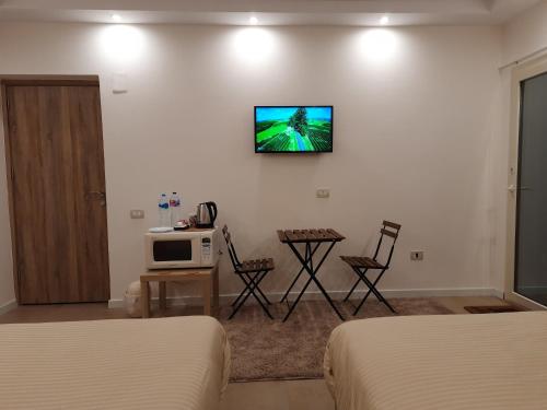 开罗Fantastic new rooms close to New Cairo Festival City and airport的酒店客房设有两张床和一台墙上的电视。