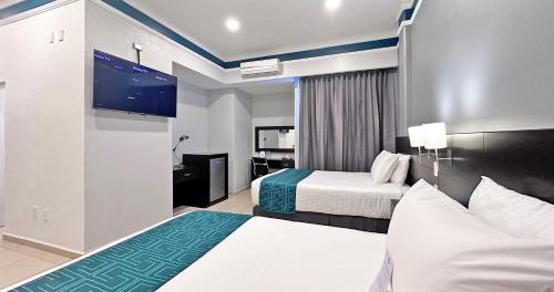 莱昂InHouse León的酒店客房设有两张床和一台平面电视。