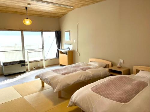 藏王温泉塔卡萨戈雅日式旅馆的一间卧室设有两张床和大窗户