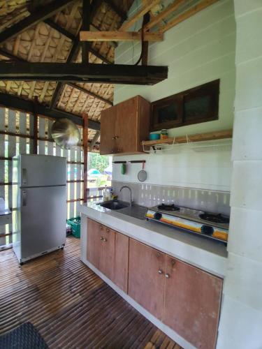ManiwayaIslas Moriones Beach Resort的厨房配有不锈钢冰箱和木制橱柜