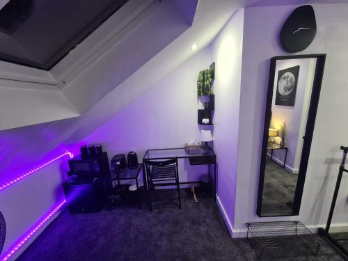 沃特福德Hornet's Hideout的紫色的客房配有一张桌子和一面镜子