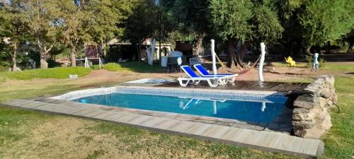 蒂诺加斯塔Encuentro de Almas (Soulmate Encounter)的一个带2把蓝色椅子和桌子的游泳池