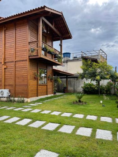 ItapemirimMillicent Residence - Chalet Milly e Chalet Iris - Itaoca Praia - ES的带阳台和草地庭院的房子