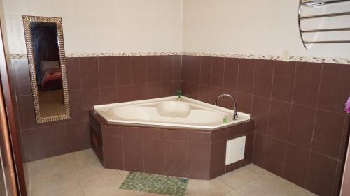 巴拿马城艾尔阿曼内瑟之家酒店的浴室设有浴缸,铺有棕色瓷砖。