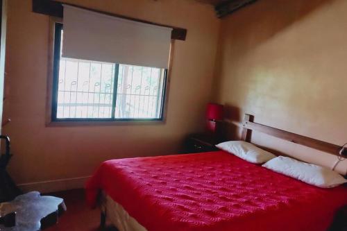 SiguatepequeCabaña La tortuga的一间卧室配有一张红色的床和窗户