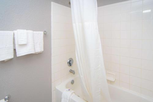 西棕榈滩西棕榈滩6号一室公寓酒店的浴室配有浴缸、淋浴和毛巾。