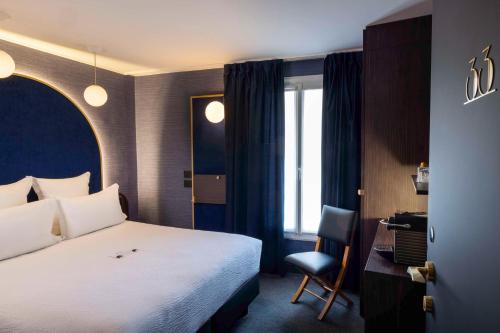 巴黎最佳西方布列塔尼蒙帕纳斯酒店的一间卧室配有一张床、一张桌子和一把椅子