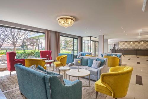 普罗夫迪夫Hotel Imperial Plovdiv, a member of Radisson Individuals的大堂设有蓝色和黄色的椅子和桌子