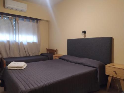 布宜诺斯艾利斯Hotel Manzanares Plaza的卧室配有床、椅子和窗户。