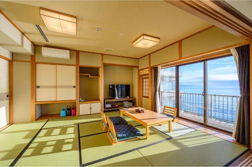 别府Ooedo Onsen Monogatari Beppu Seifu的一间带桌子的客厅和一个阳台
