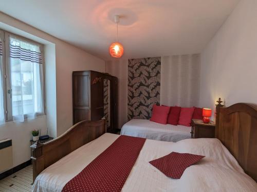 Jeu-MalochesGîte Jeu-Maloches, 4 pièces, 7 personnes - FR-1-591-60的一间卧室配有两张带红色枕头的床
