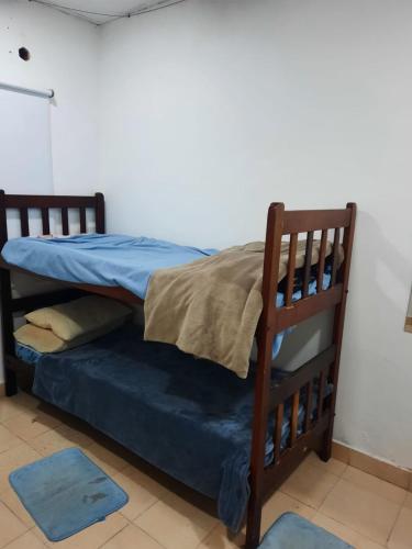 罗克萨恩斯培尼亚总统城Lo de Milo的配有蓝色床单和枕头的宿舍间内的一张双层床