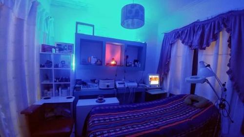 拉普拉塔Habitación privada, La Plata的一间设有床铺的卧室,位于蓝色灯光的房间