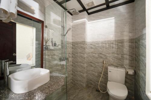 会安RAON Hoian Beach的浴室配有卫生间、盥洗盆和淋浴。