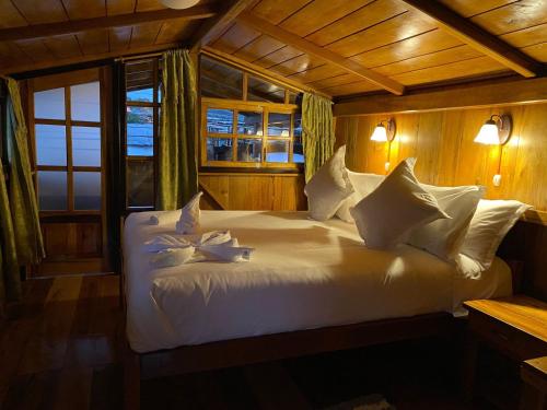 明多Guayabo Hostal Spa的一间卧室配有带白色床单和枕头的床。