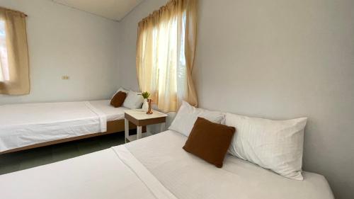 波尔多·格尼拉Manalo's Lodge and Restaurant的一间小卧室,配有两张床和窗户
