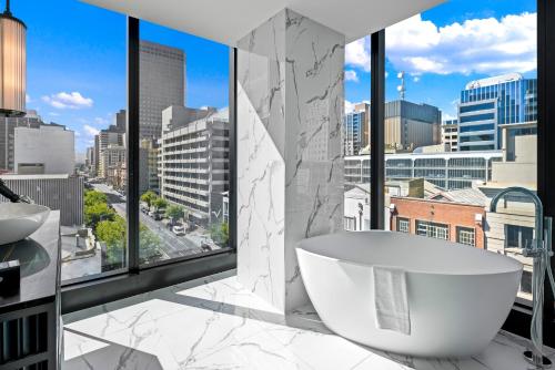 阿德莱德Sofitel Adelaide的一间带浴缸的浴室,享有城市美景