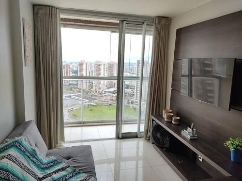 巴西利亚Maravilhoso Apartamento em Brasília DF的客厅设有大窗户和电视。
