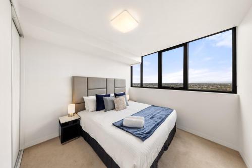 墨尔本Convenient Located 1bedroom apartment in St Kilda的一间卧室设有一张大床和大窗户