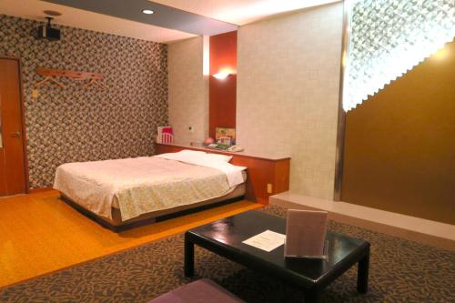 鸟栖市Hotel Silk no Mori (Adult Only)的酒店客房配有一张床铺和一张桌子。