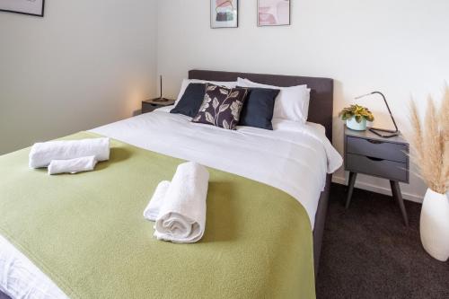 基督城Central City Comfort: 2 Bedroom Gem W/free Carpark的一间卧室配有一张大床和毛巾