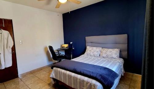 萨尔蒂约Casa Arboleda的一间卧室设有一张床和蓝色的墙壁