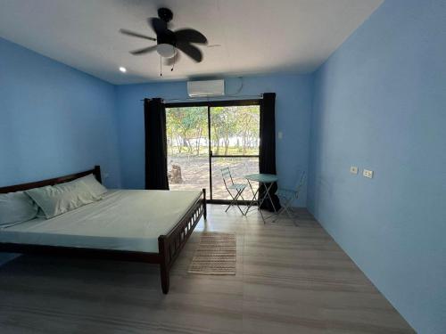 布桑加Magalong Villa at Holy Land in Busuanga的一间卧室配有一张床和吊扇