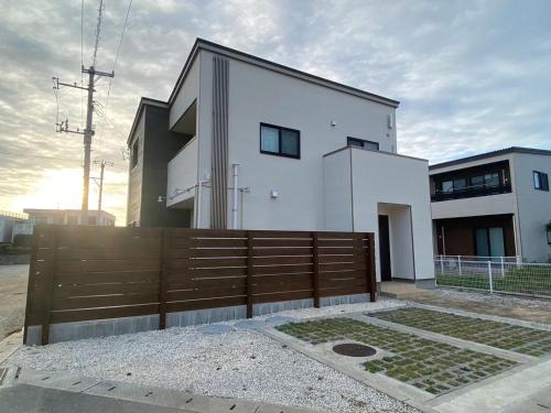 宫古岛Rs Stay Villa MIYAKO B的前面有木栅栏的白色房子
