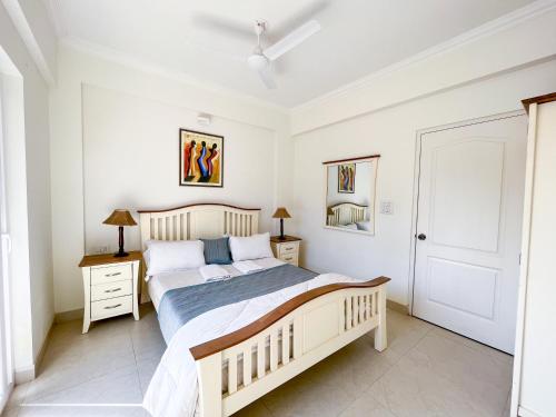 RevoraB&F Meadows - Your Premier Apartment Hotel的一间卧室设有一张大床和两个床头柜
