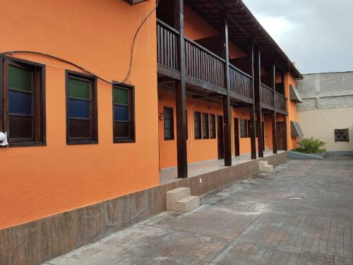 瓜拉派瑞Hotel Pousada Em Guarapari - Pousada Paraiso的一座橙色的建筑,上面有很多窗户