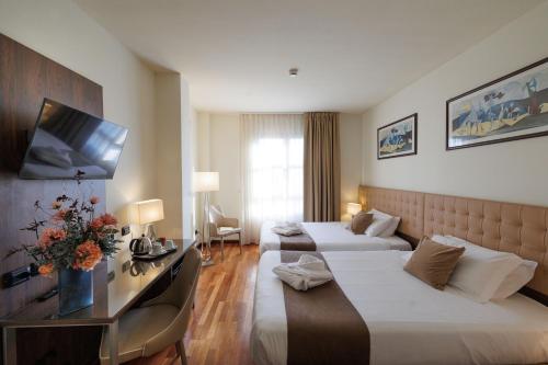 普拉托魅力四射酒店的酒店客房设有两张床和一台平面电视。