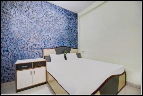 印多尔HOTEL SATYAM SHREE的卧室配有白色的床和蓝色的墙壁