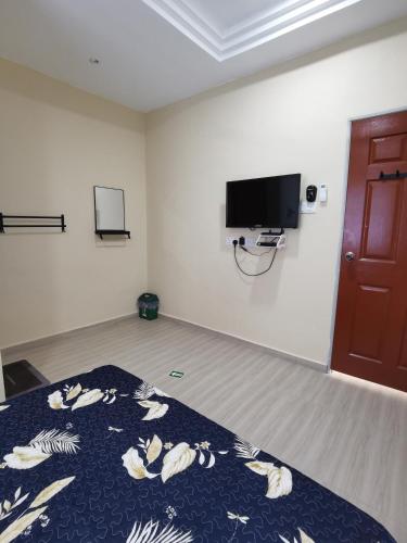 关丹Roomstay Villa Tok Wan的客房设有一张床和一台平面电视。