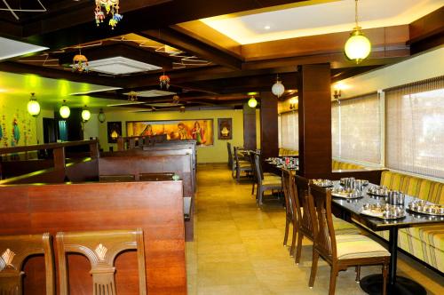 乌贾因Hotel Ashray的餐厅内带桌椅的用餐室