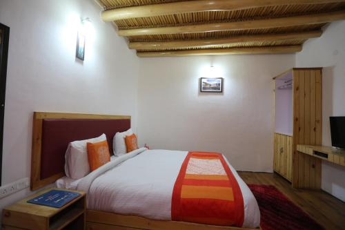 列城Hotel Lhalingkha的一间带大床和电视的卧室