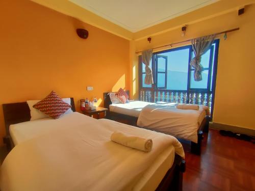 班迪普尔班迪波卡辛宾馆的酒店客房设有两张床和窗户。