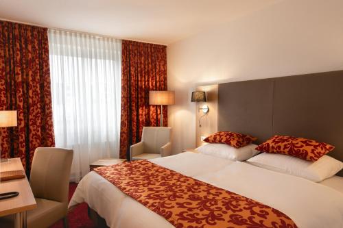 杜塞尔多夫艾斯特拉酒店的一间设有大床和窗户的酒店客房