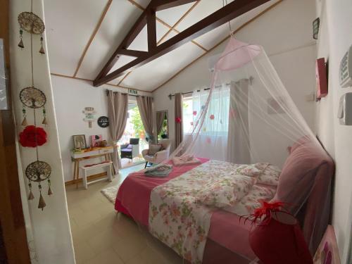 特鲁欧克比赫斯Chambre D'hote PLACE DES AMOUREUX的一间卧室配有一张带蚊帐的床