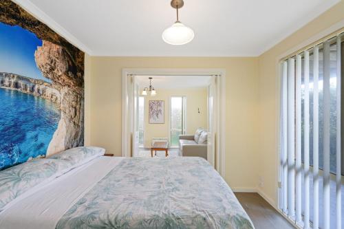 圣雷莫Oceanview Family Retreat的卧室配有一张大床,墙上挂有绘画作品