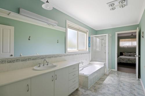 圣雷莫Oceanview Family Retreat的带浴缸、水槽和浴缸的浴室