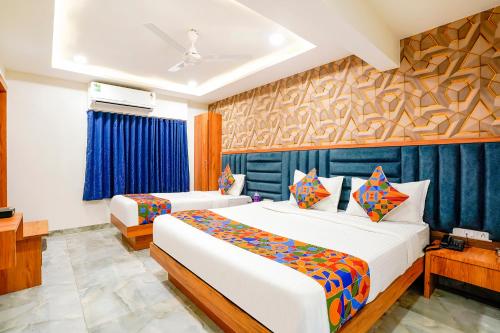 艾哈迈达巴德FabHotel Nobel Inn的一间卧室设有两张床和蓝色的墙壁