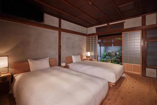 太宰府市HOTEL CULTIA DAZAIFU的配有2张床的带窗户和2盏灯的客房