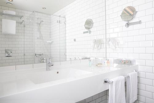 莫斯斯托维酒店的白色的浴室设有浴缸和水槽。