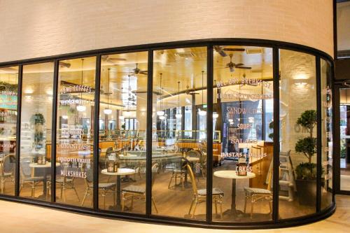 吉隆坡KUALA LAMPUR LUCENTIA RESIDENCE KLCC的餐厅设有玻璃窗户和桌椅