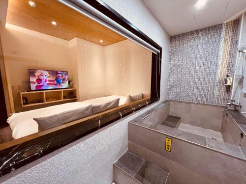 鱼池乡日月潭沅居民宿 YUAN JU BOUTIQUE Hotel的带浴缸、床和电视的浴室