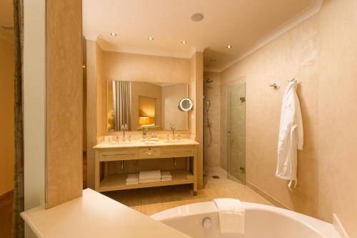 格吕克斯堡阿尔特迈尔霍夫维塔尔酒店的带浴缸、水槽和镜子的浴室