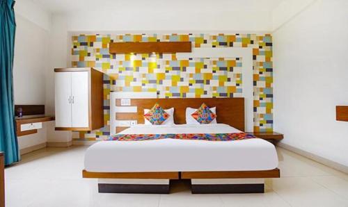 班加罗尔FabHotel Emirates Suites的一间卧室配有一张大床和色彩缤纷的床头板