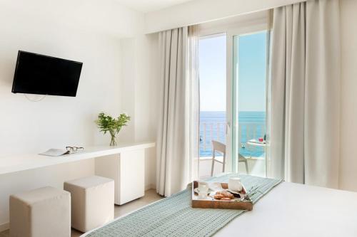 勒托阳尼Albatros Beach Hotel的海景白色卧室